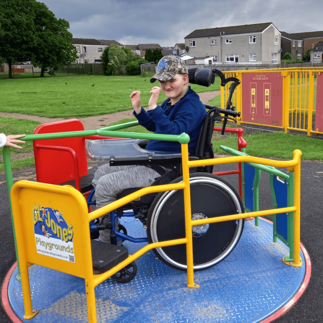 FCSS - A boy in a wheelchair playing on a merry go round