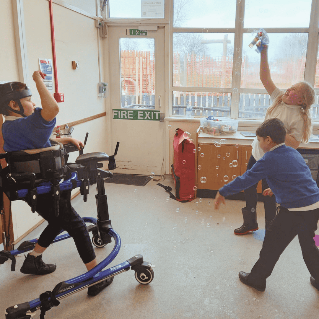 FCSS - Three children playing with bubbles in a class room