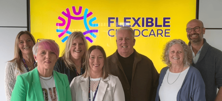 Members of the Flexible Childcare Team and Board in front of their new logo